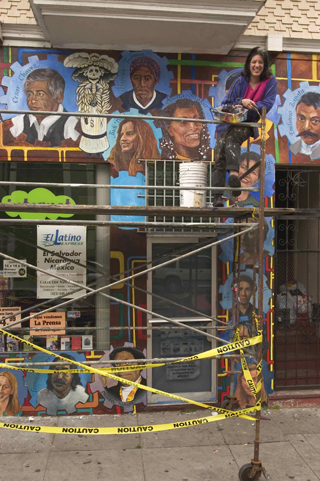 Susan Greene in front of her San Francisco mural La Lucha Continua